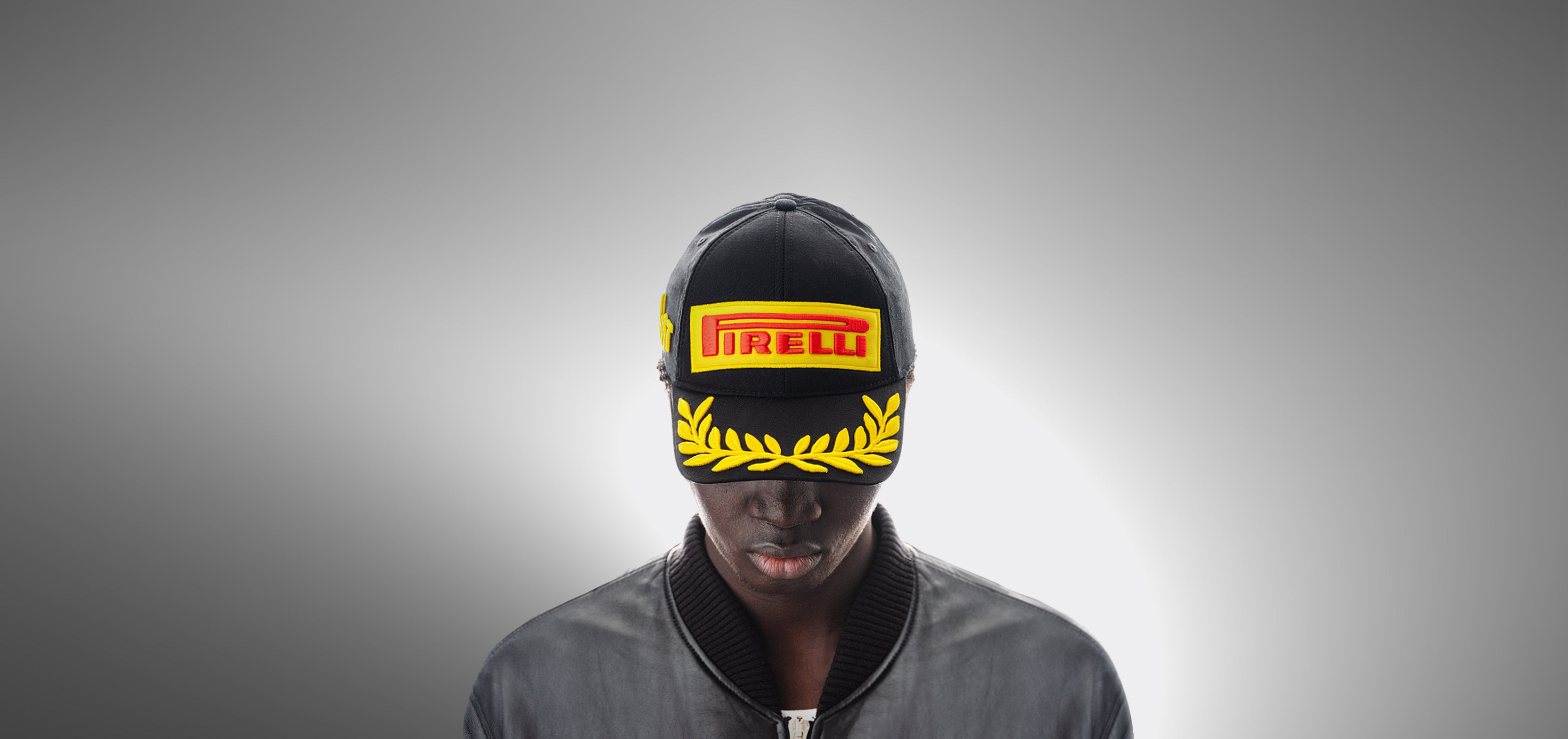 Person wearing a Pirelli Podium Cap - Black F1® on a gray background