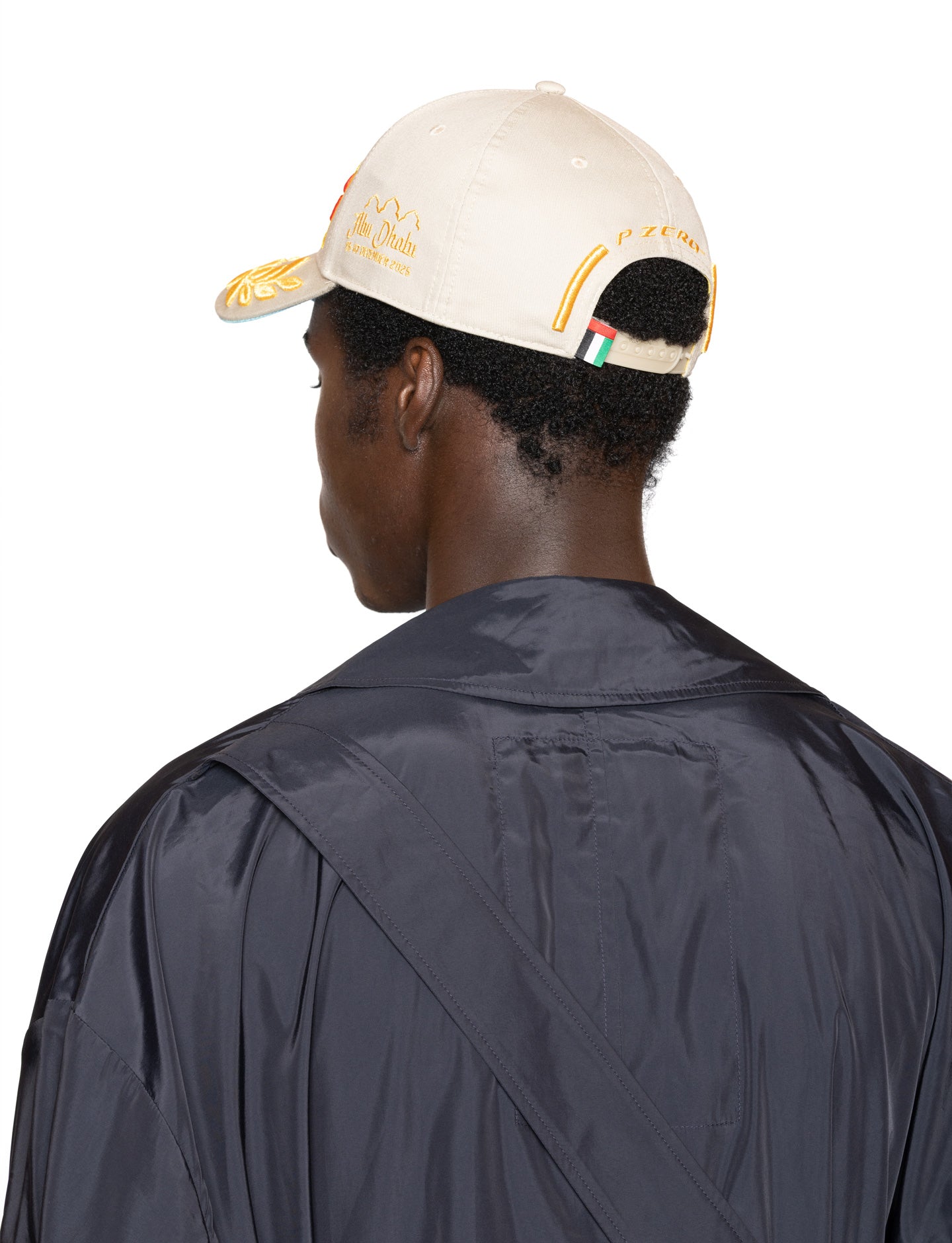 Person wearing a beige cap with a UAE woven lab flag on the snapback