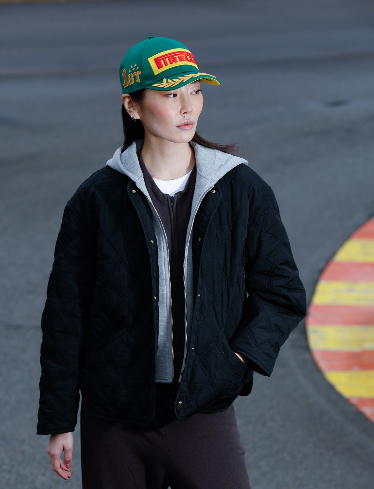 woman with green Pirelli cap at racetrack