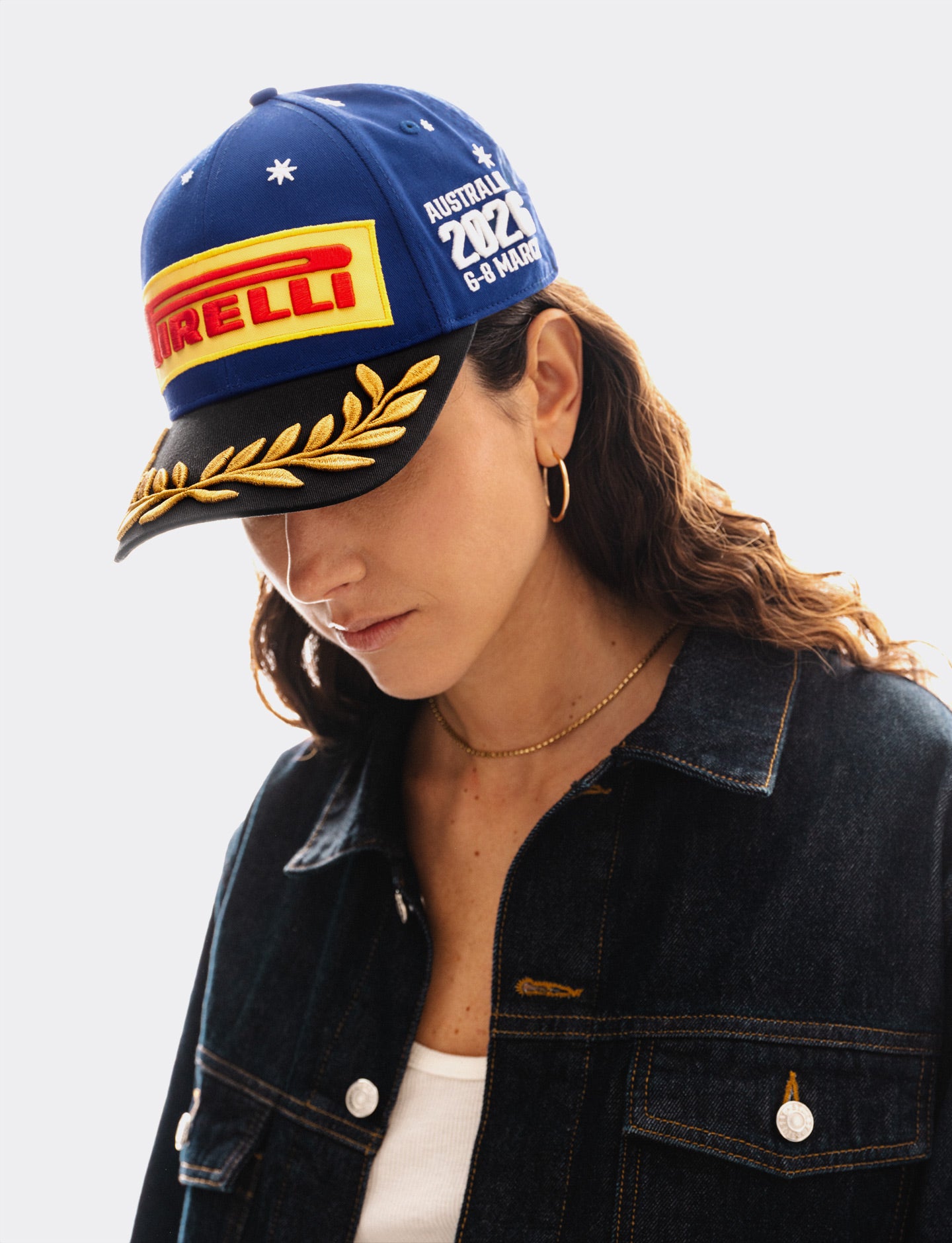Person wearing a blue Pirelli Podium Cap with Pirelli logo and 'Australia 2026' text on a white background
