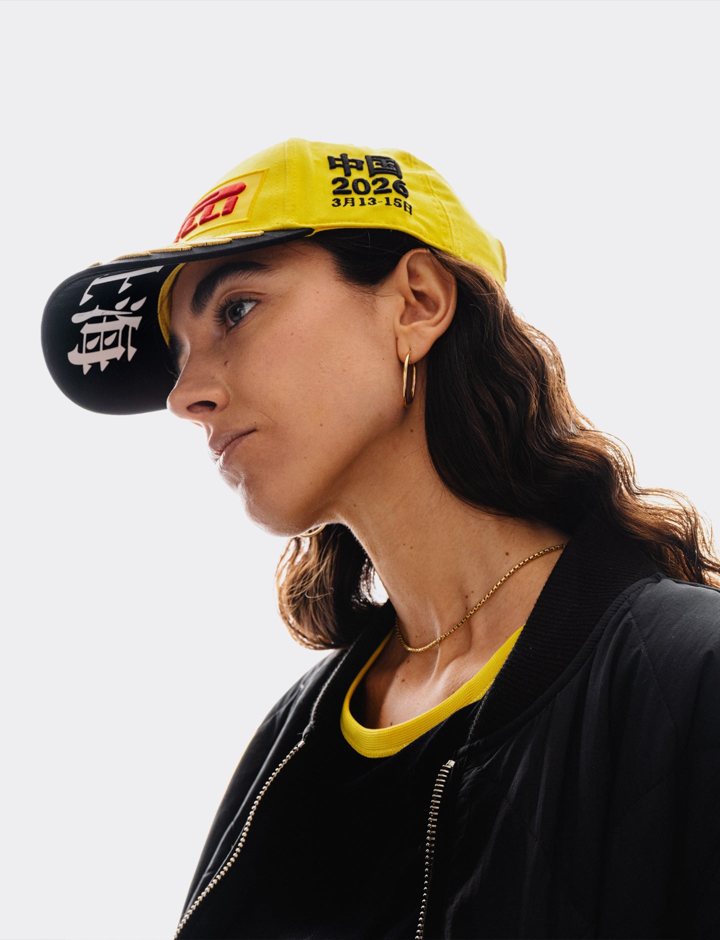 Person wearing a yellow and black cap with visible branding against a light background