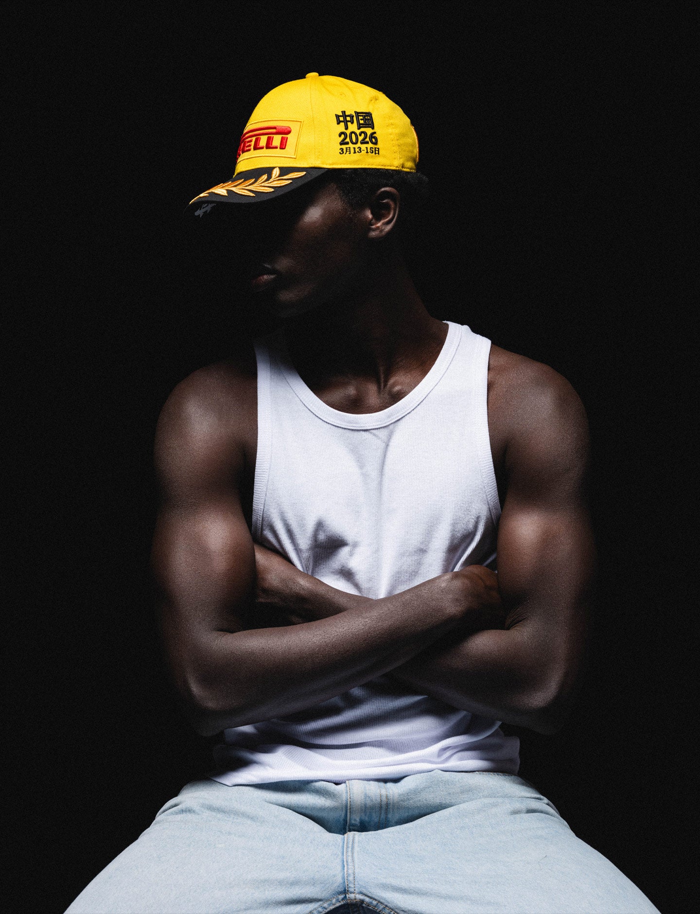 man wearing yellow Pirelli Podium Cap against a black background