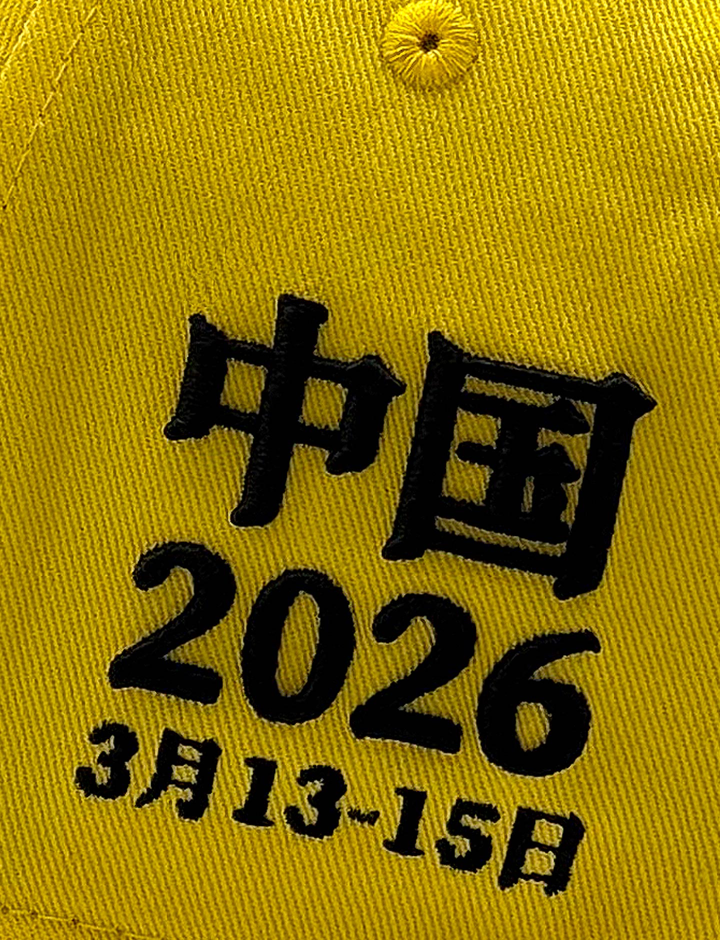 Yellow cap with black text '中国 2026 3月13-15日' on a yellow background