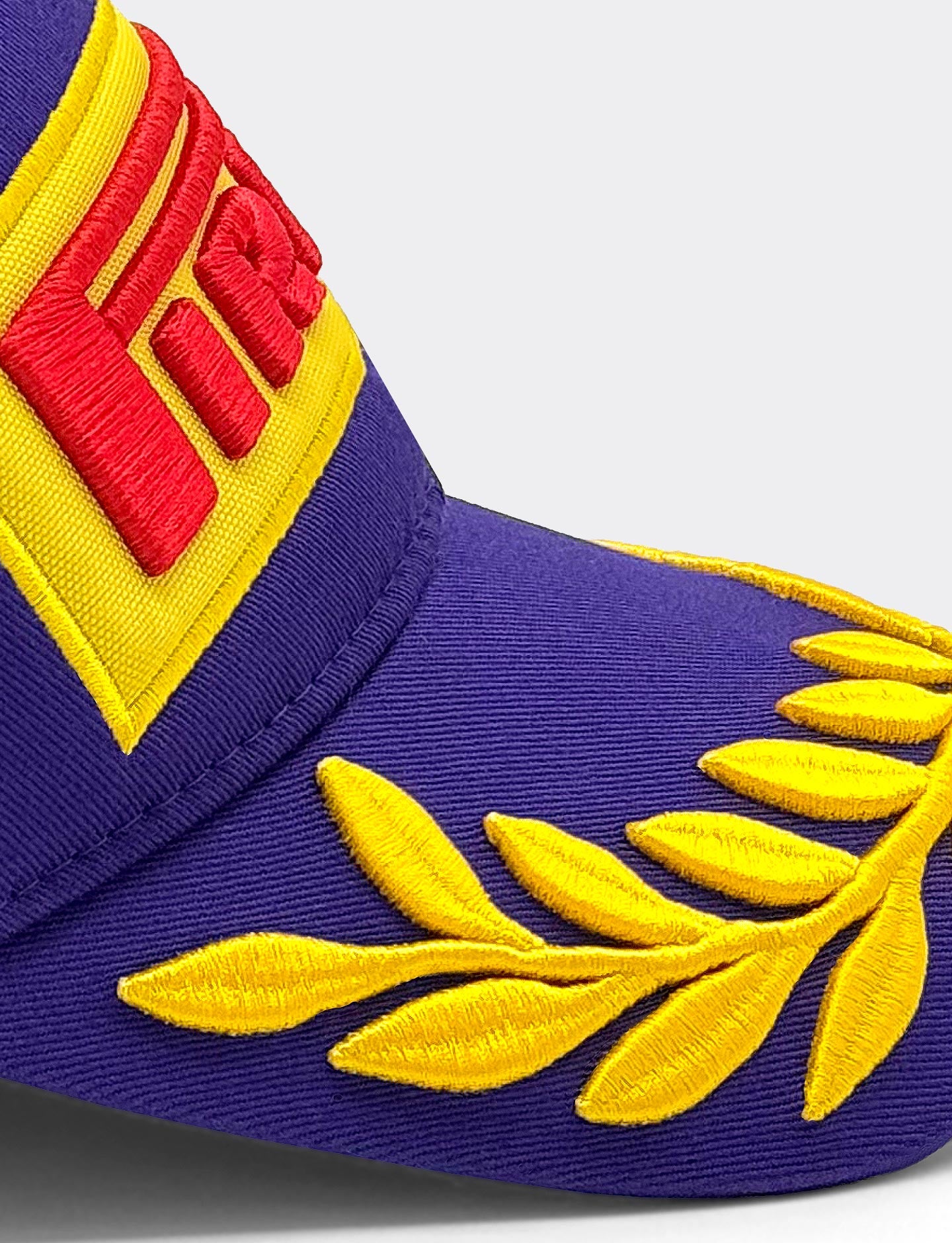 Blue cap with yellow embroidered design and red Pirelli logo on a light gray background