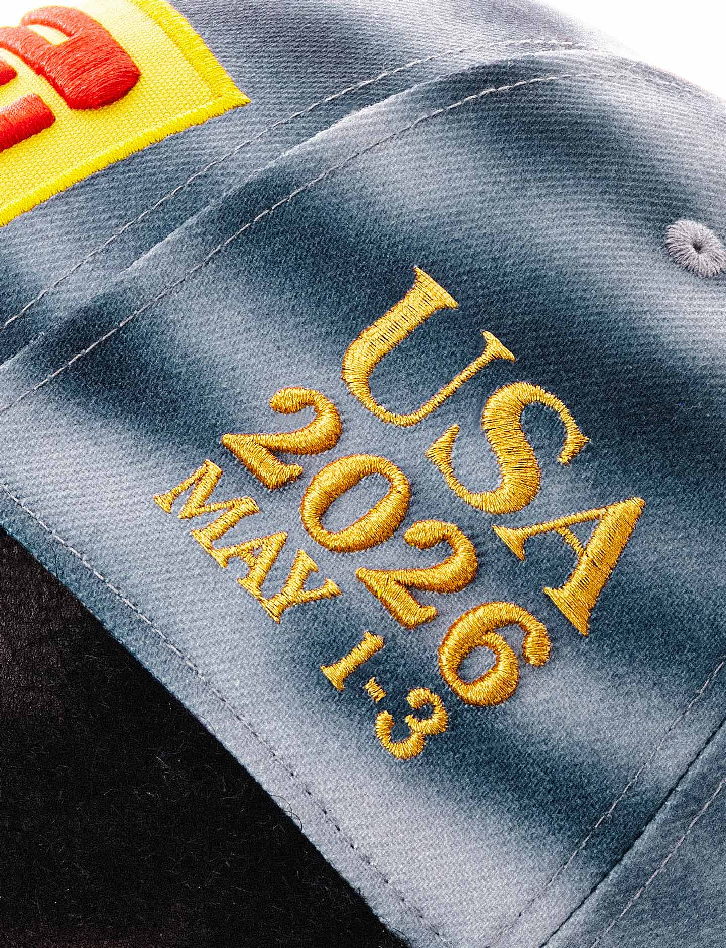 Embroidered text on a cap with 'USA 2026 MAY 1-3' and a Pirelli logo in the corner.