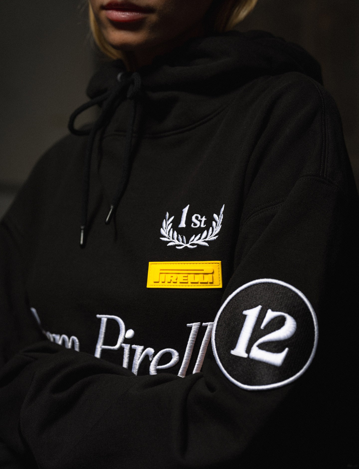 Black Pirelli hoodie with embroidered text and logos on a dark background