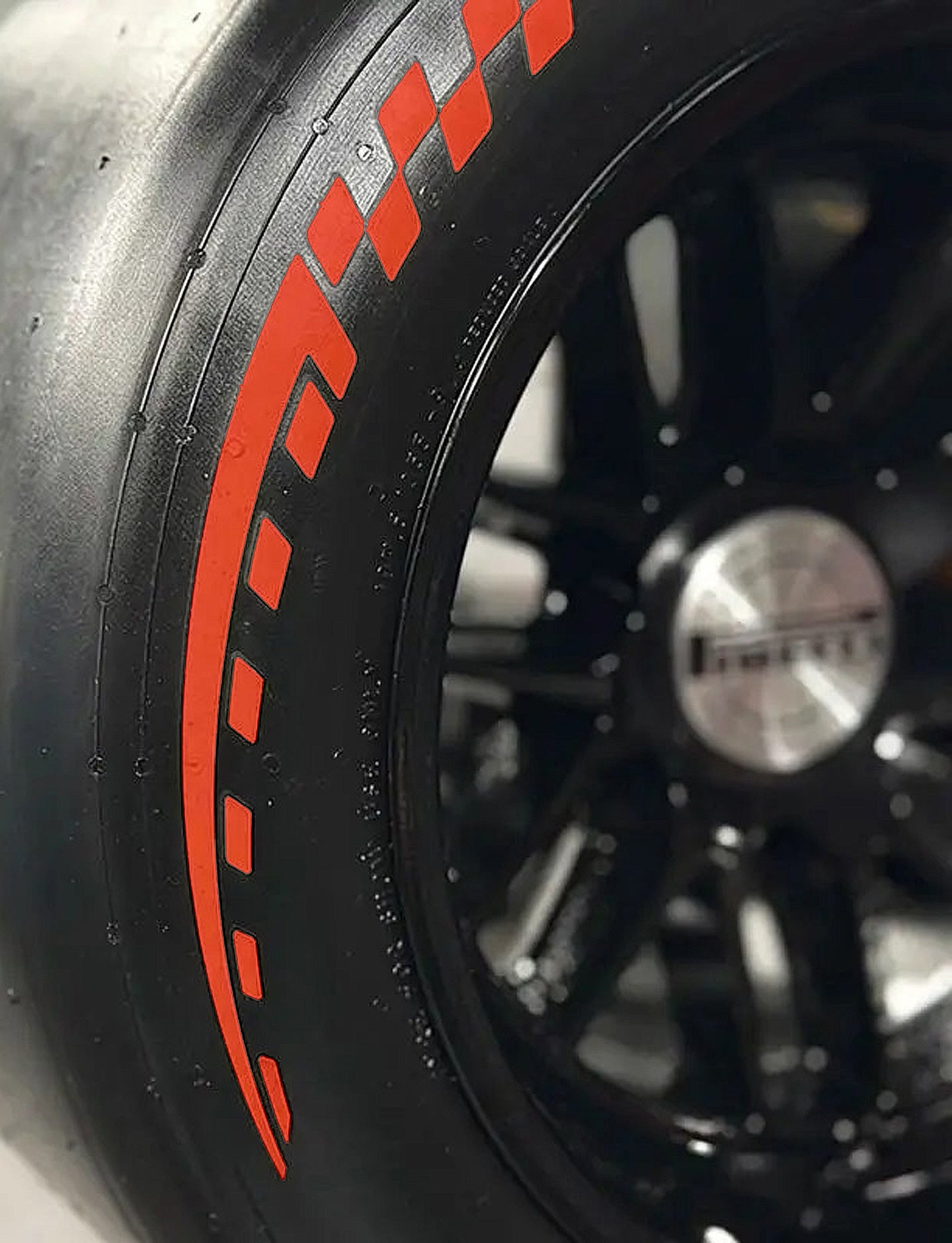Close-up of a tire with red design and a black rim with a visible Pirelli brand logo.